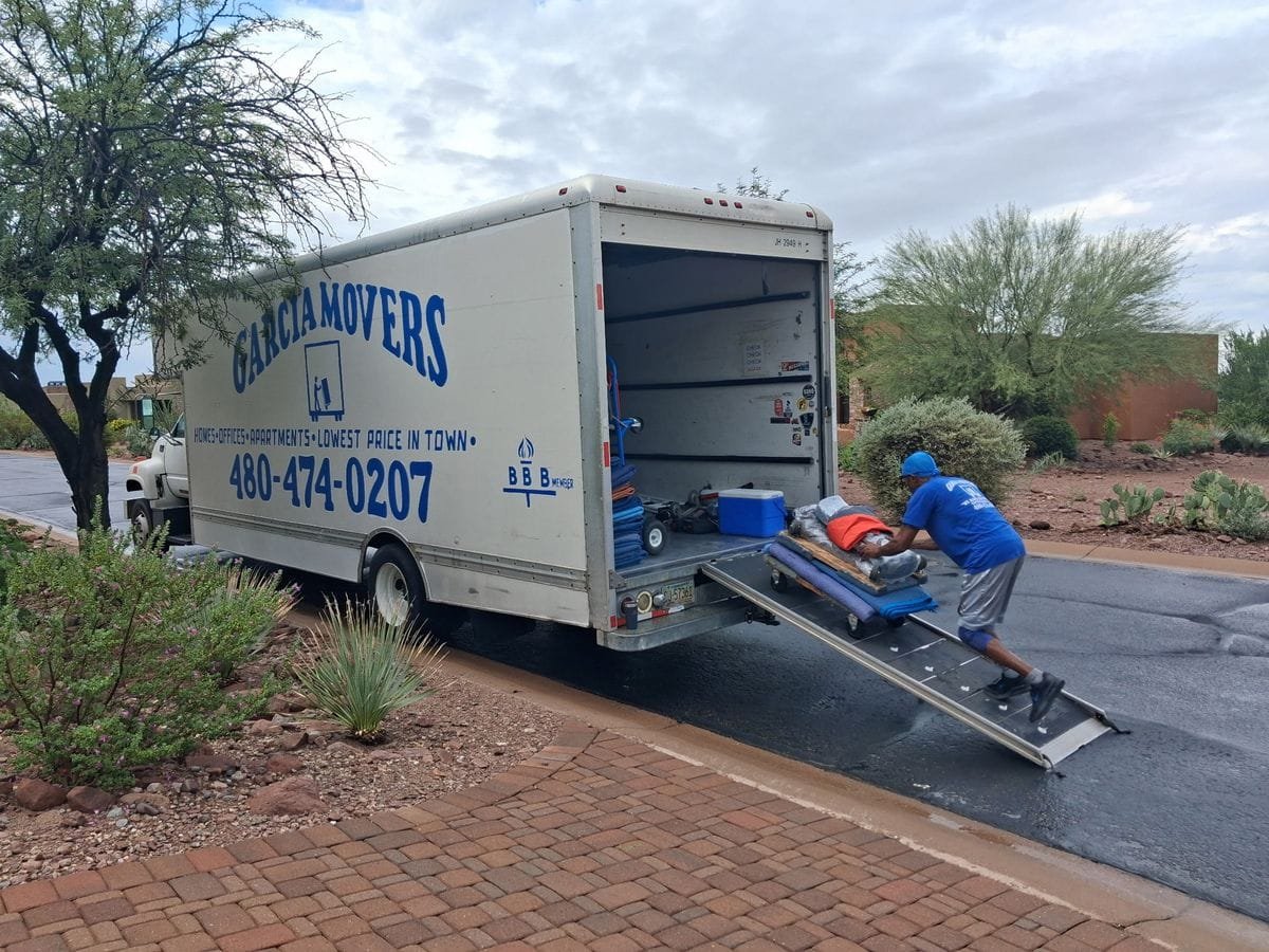 A Garcia mover pushing a loaded dolly up the ramp into the truck