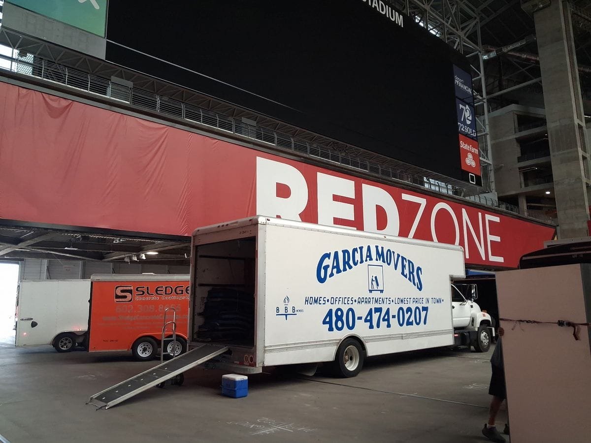 A Garcia Movers truck with its ramp down inside State Farm Stadium