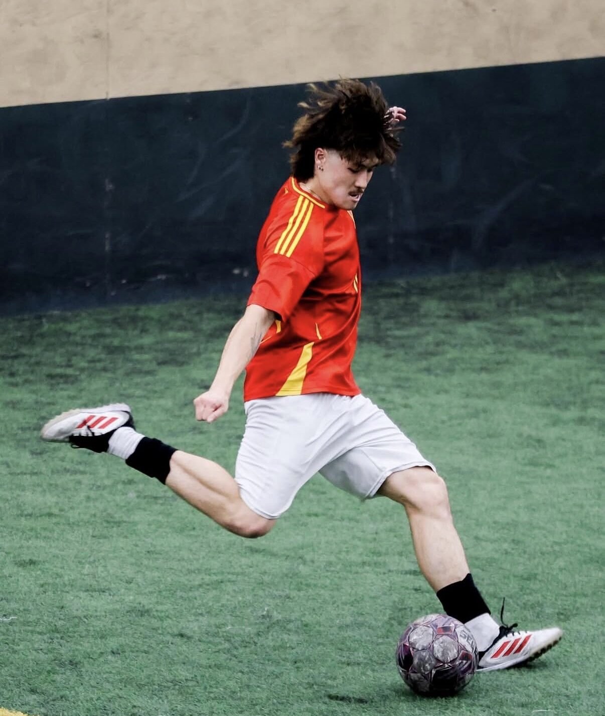 PSC player kicking ball on indoor turf
