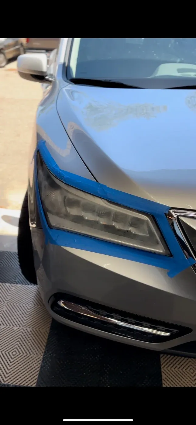 Faded, taped-off Acura front end before detailing